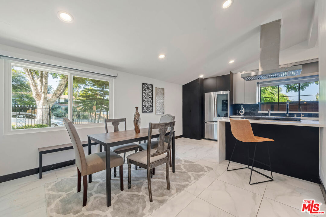 20412 Oxnard Street Woodland Hills, CA 91367 - Photo 21 of 35 a dining room with kitchen island furniture a large window and chairs