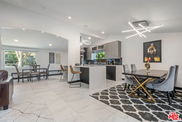 a open kitchen with stainless steel appliances granite countertop a stove a sink a dining table and chairs