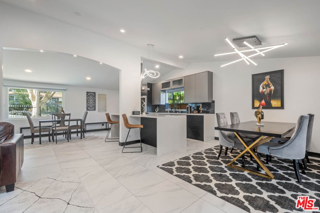 20412 Oxnard Street Woodland Hills, CA 91367 - Photo 24 of 35 a open kitchen with stainless steel appliances granite countertop a stove a sink a dining table and chairs