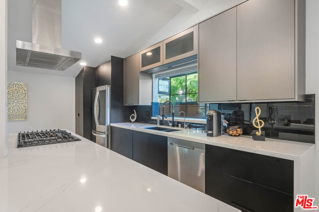 20412 Oxnard Street Woodland Hills, CA 91367 - Photo 25 of 35 a kitchen with stainless steel appliances a sink stove and refrigerator
