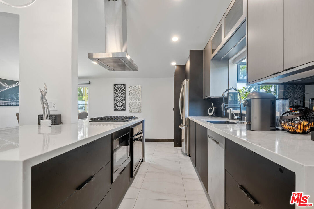 20412 Oxnard Street Woodland Hills, CA 91367 - Photo 26 of 35 a kitchen with stainless steel appliances a sink stove and cabinets