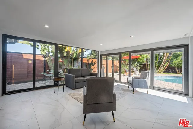 a living room with furniture and large windows