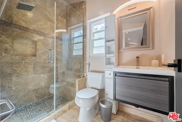 a bathroom with a toilet a sink and glass door