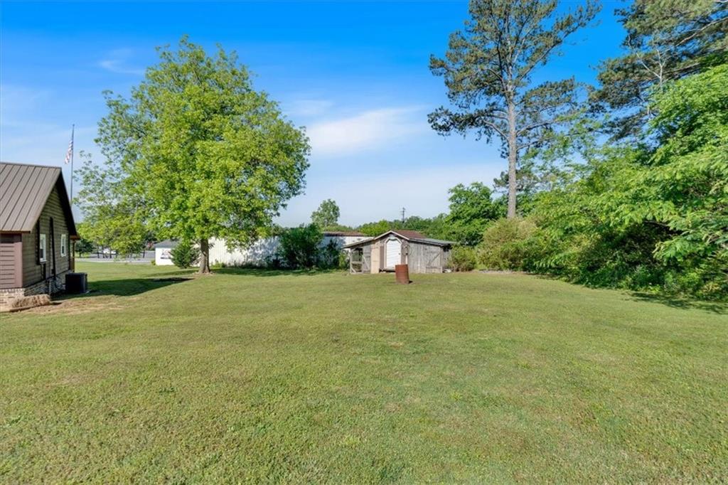 3049 Highway 411 White, GA 30184 - Photo 36 of 49 a tall yellow house with a big yard plants and trees all around