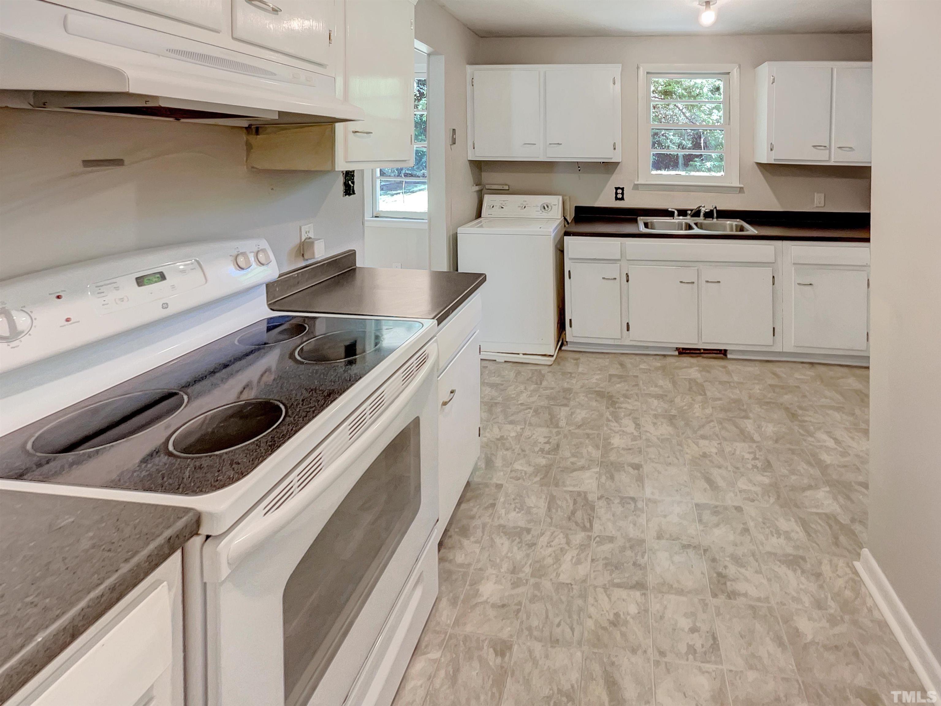 2011 Waters Drive Raleigh, NC 27610 - Photo 11 of 18 a kitchen with granite countertop a sink a stove and cabinets