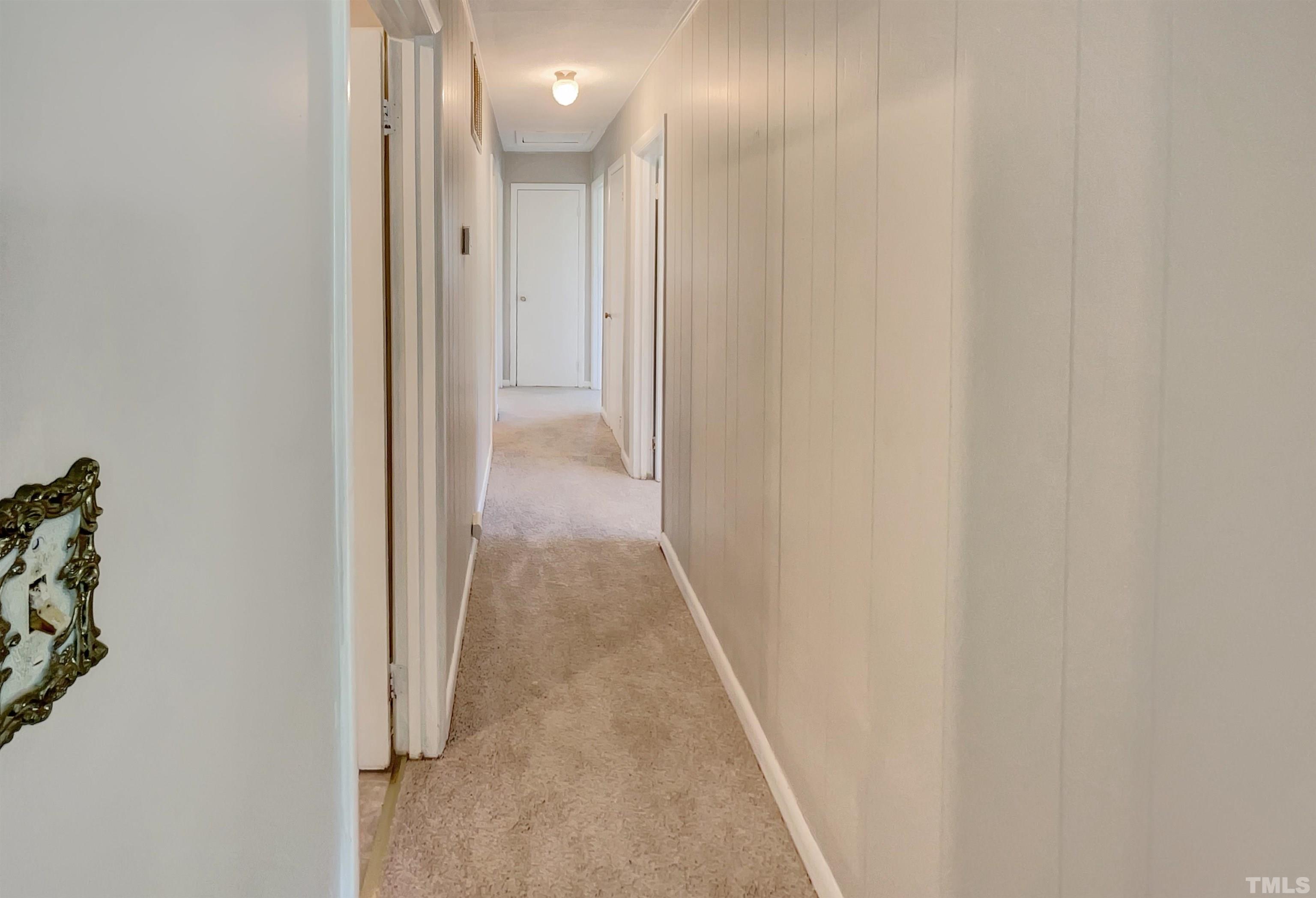 2011 Waters Drive Raleigh, NC 27610 - Photo 5 of 18 a view of a hallway with wooden floor and a bathroom