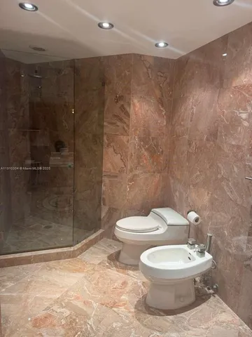 a bathroom with a toilet a sink and shower