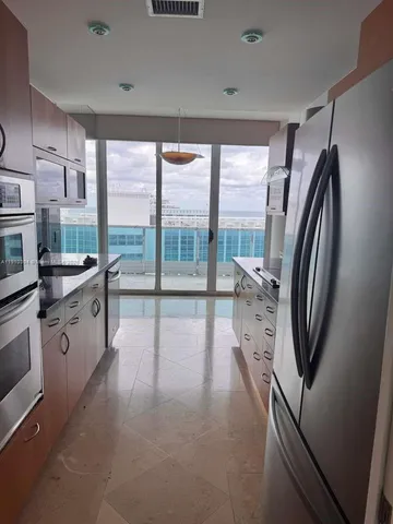 a kitchen with stainless steel appliances a sink and a large window