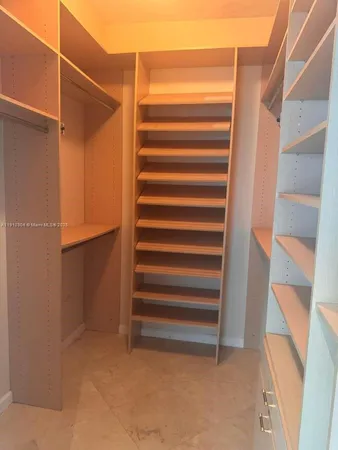 a view of closet with wooden floor and stairs