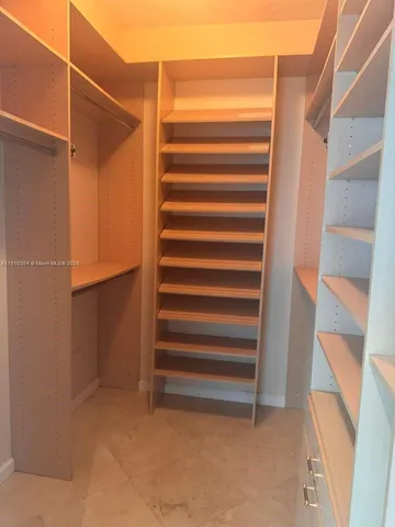 a view of closet with wooden floor and stairs