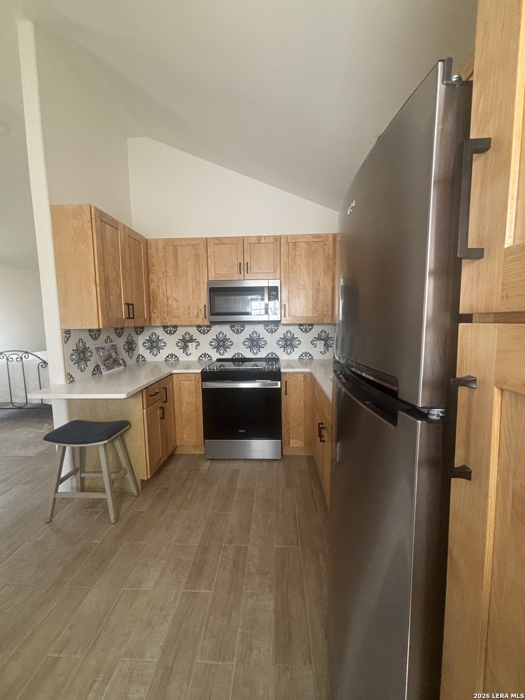 18014 Scenic Loop Road, Unit A Helotes, TX 78023 - Photo 4 of 22 a kitchen with stainless steel appliances granite countertop a refrigerator a stove a sink dishwasher and a refrigerator