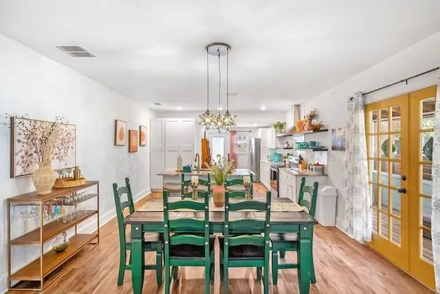 a kitchen with stainless steel appliances granite countertop a table chairs stove and cabinets