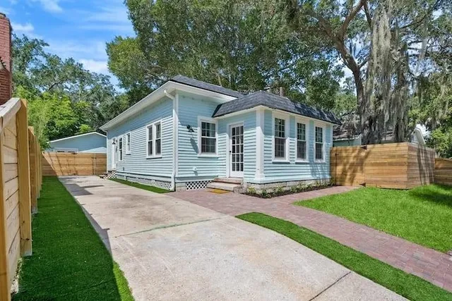 a front view of a house with a small yard and fence