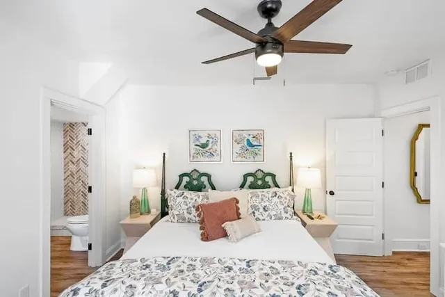 a bedroom with a large bed and ceiling fan