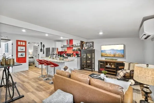 a living room with furniture a flat screen tv and a window