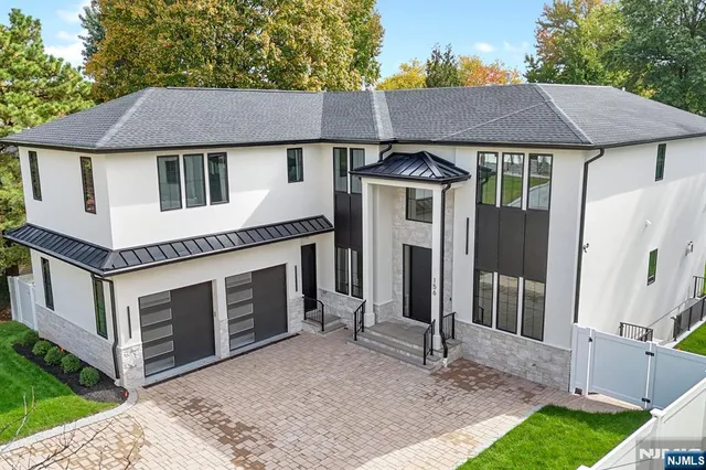 a front view of a house with a garden and trees