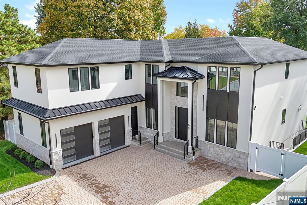 a front view of a house with a garden and trees