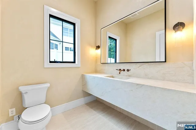 a bathroom with a toilet a sink and mirror