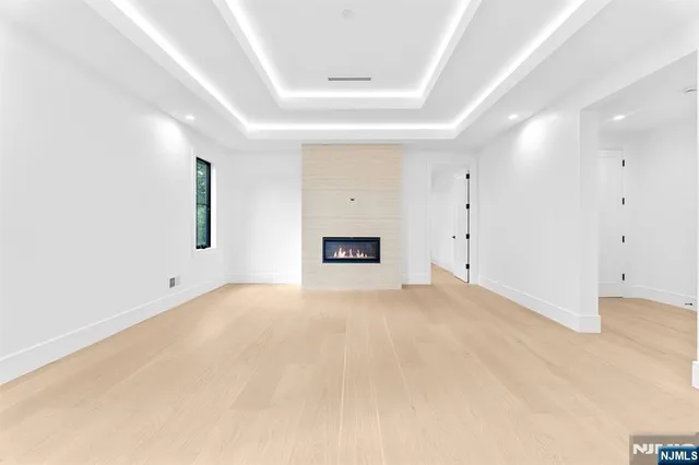 an empty room with a windows and a ceiling fan