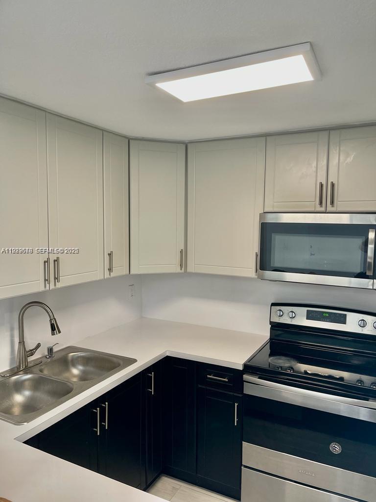 8050 Northwest 8th Street, Unit 201 Miami, FL 33126 - Photo 6 of 13 a kitchen with a sink and cabinets