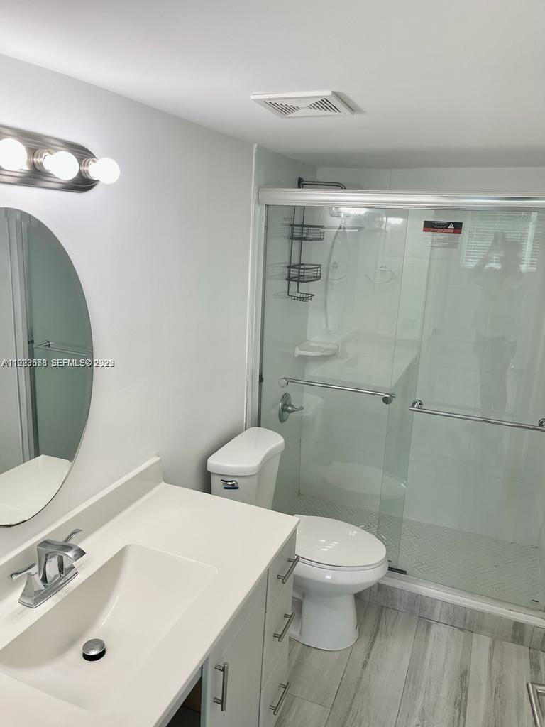 8050 Northwest 8th Street, Unit 201 Miami, FL 33126 - Photo 9 of 13 a bathroom with a toilet sink and mirror