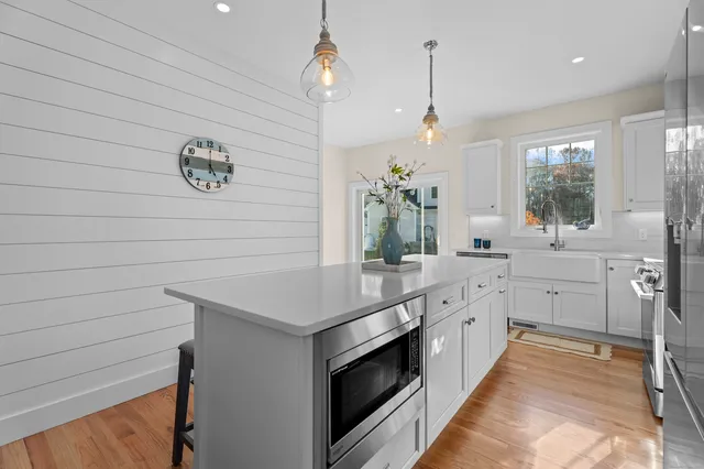 a kitchen that has a lot of cabinets in it and wooden floor