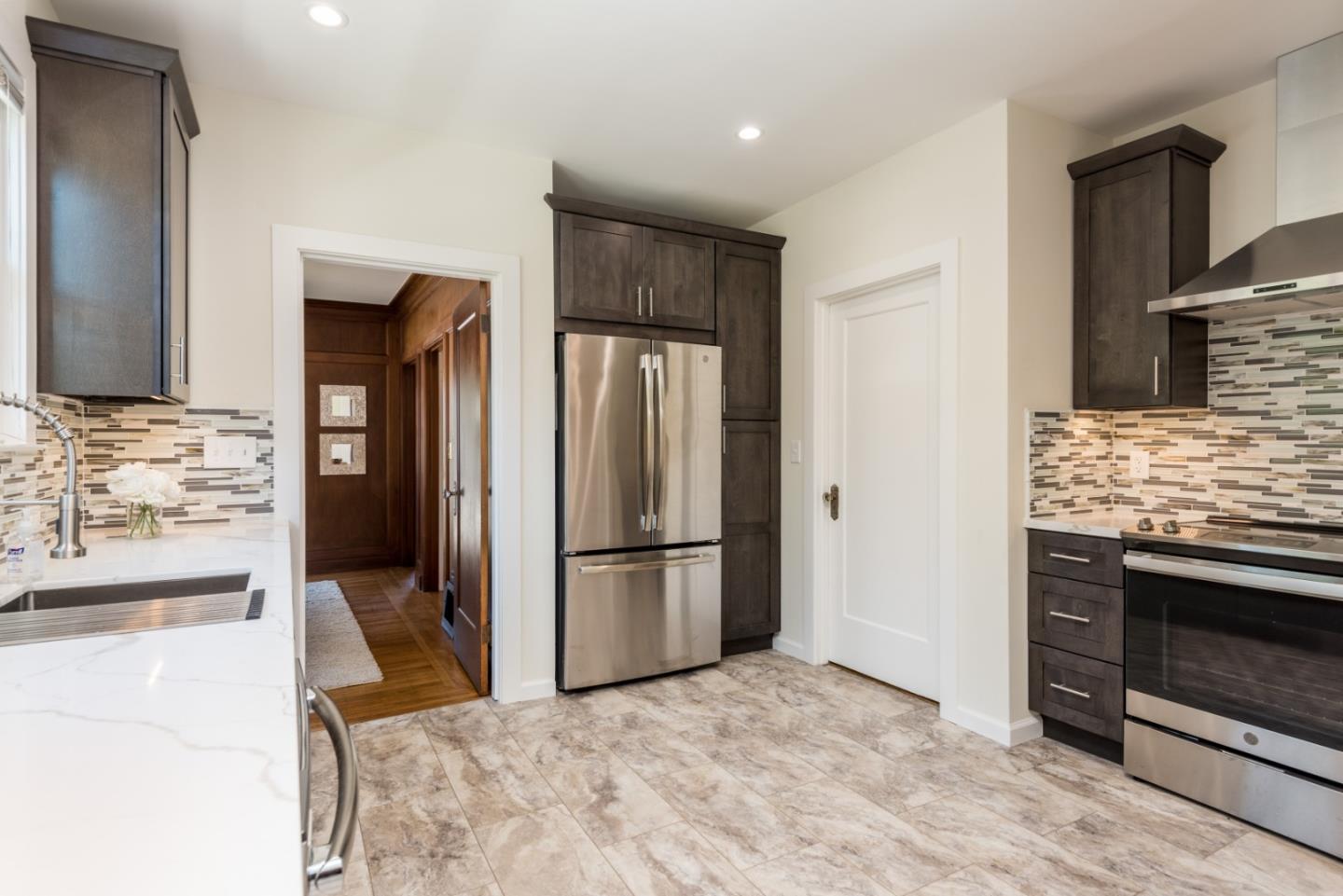739 Prospect Row San Mateo, CA 94401 - Photo 11 of 27 a kitchen with stainless steel appliances kitchen island granite countertop a refrigerator and a stove top oven