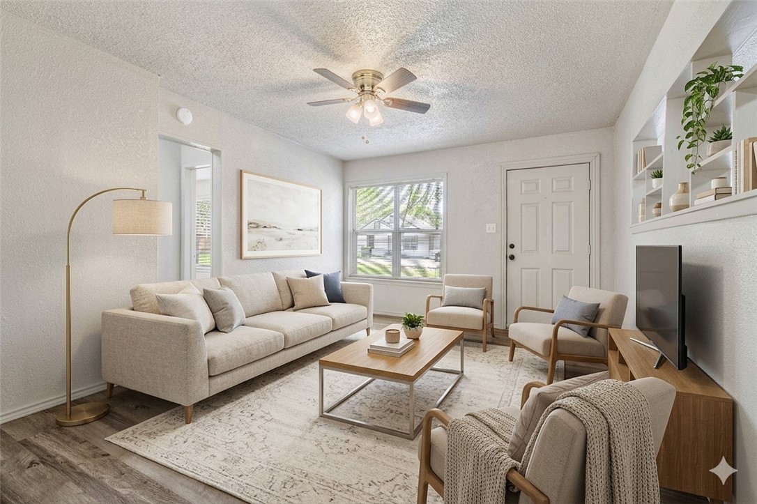 a living room with furniture a large window and a chandelier