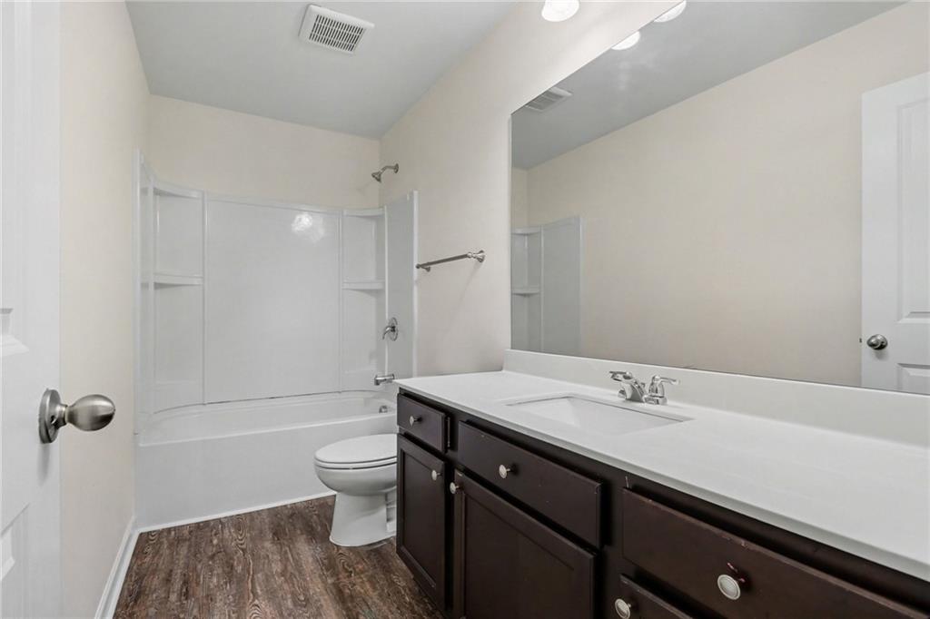 4635 Bluffton Court Cumming, GA 30028 - Photo 22 of 27 a bathroom with a sink a toilet and shower