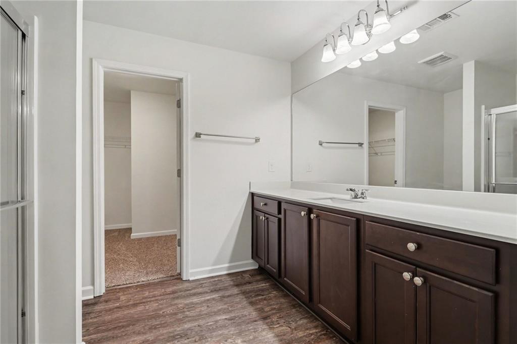 4635 Bluffton Court Cumming, GA 30028 - Photo 23 of 27 a spacious bathroom with a double vanity sink and a mirror