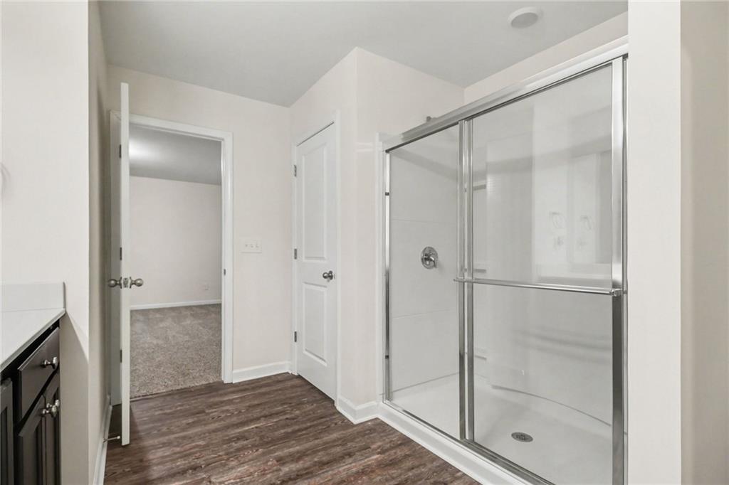 4635 Bluffton Court Cumming, GA 30028 - Photo 24 of 27 a bathroom with a glass shower door