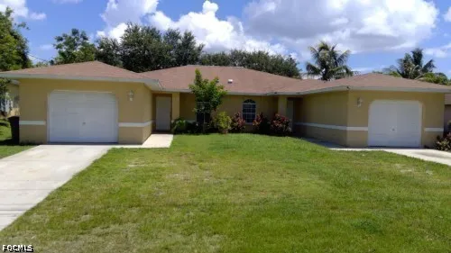 a view of a house with a yard and garage