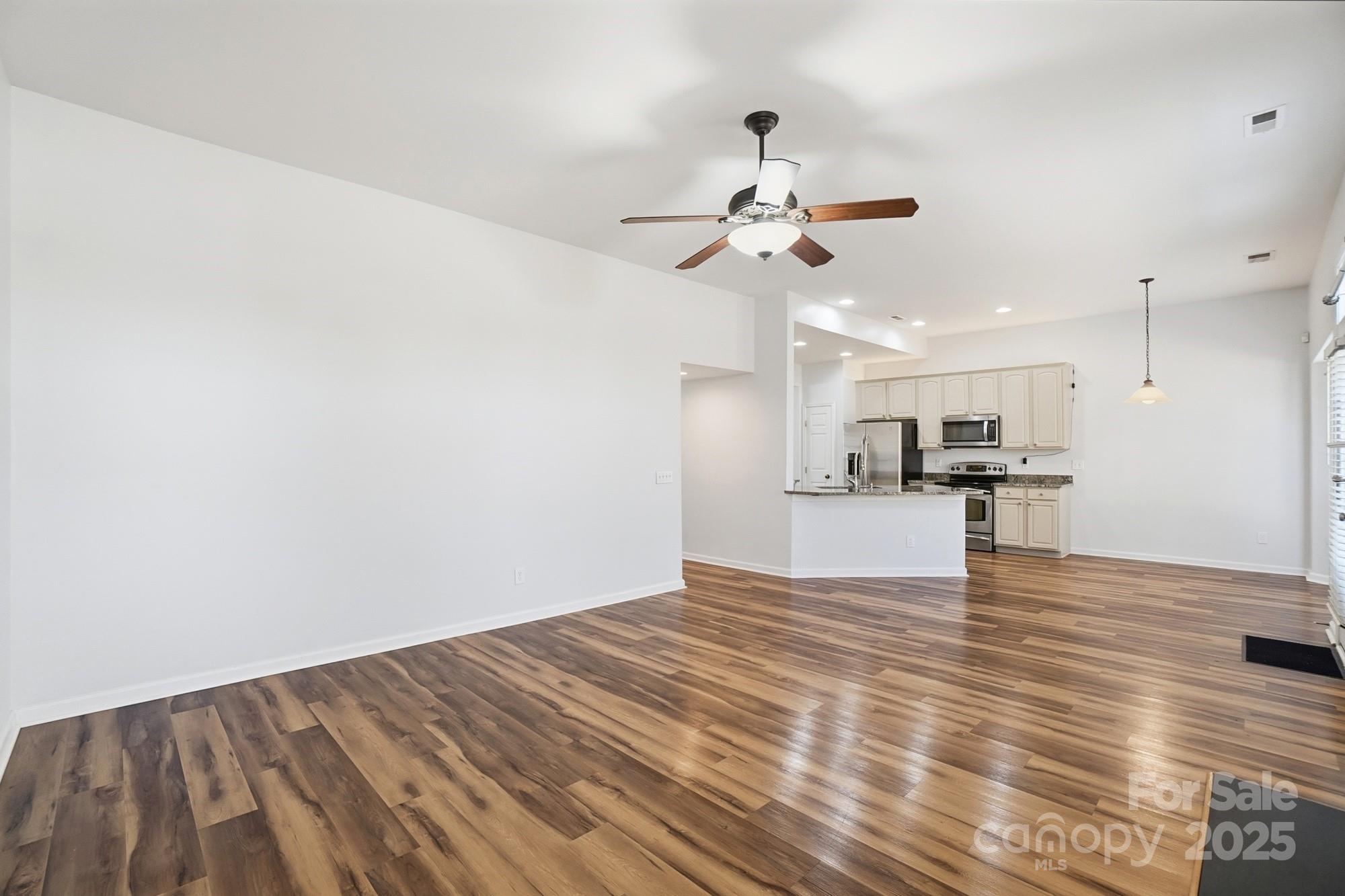 630 Springhouse Place Clover, SC 29710 - Photo 12 of 32 a view of kitchen and empty room with wooden floor