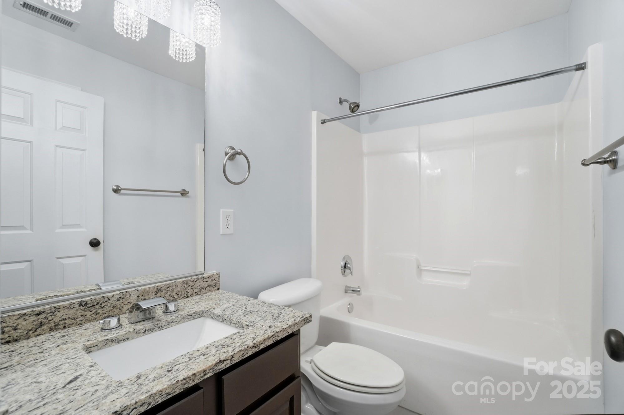 630 Springhouse Place Clover, SC 29710 - Photo 22 of 32 a bathroom with a granite countertop sink toilet a shower and a mirror