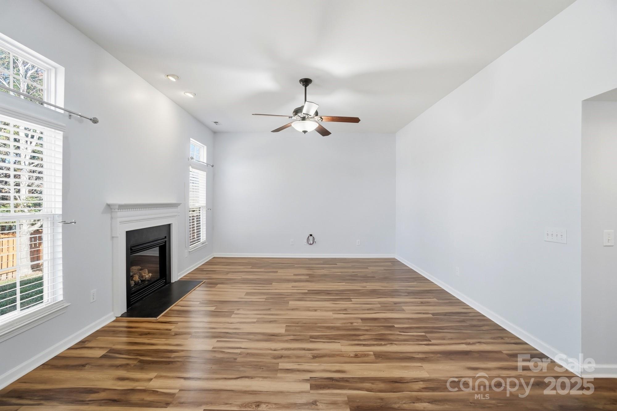 630 Springhouse Place Clover, SC 29710 - Photo 10 of 32 wooden floor in an empty room with a fireplace and a window