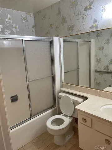 a bathroom with a granite countertop toilet and a shower