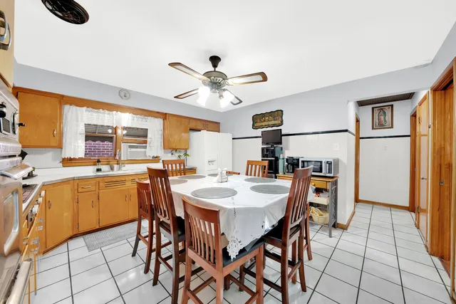 a dining room with stainless steel appliances a table and chairs