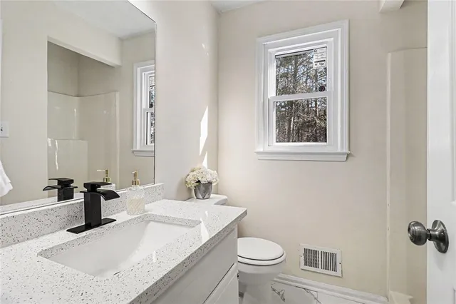 a bathroom with a sink toilet and mirror