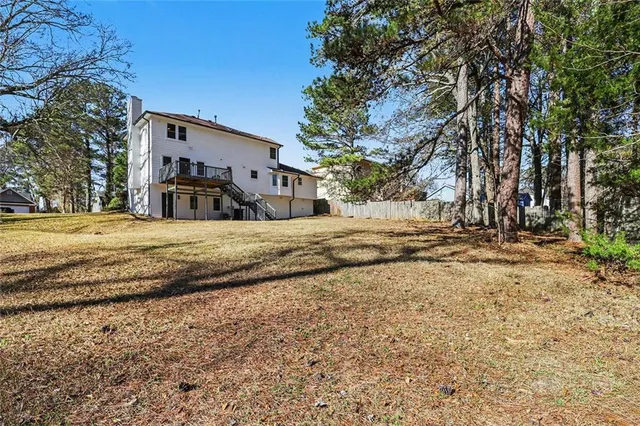 a view of a house with small yard plants and palm trees