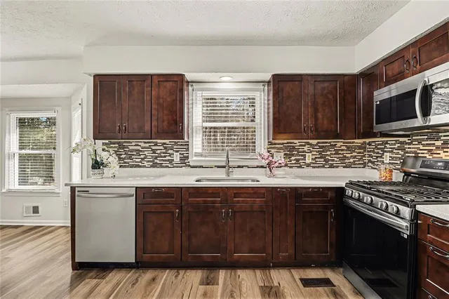 a kitchen with granite countertop a sink stove and cabinets
