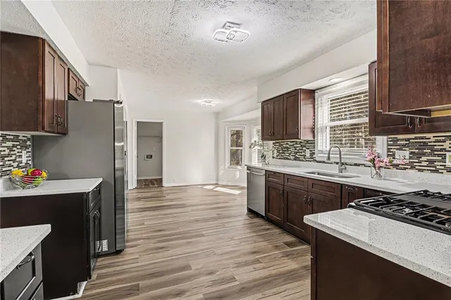 a kitchen with stainless steel appliances a stove refrigerator sink and cabinets