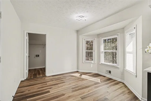 a view of a livingroom with wooden floor and a window