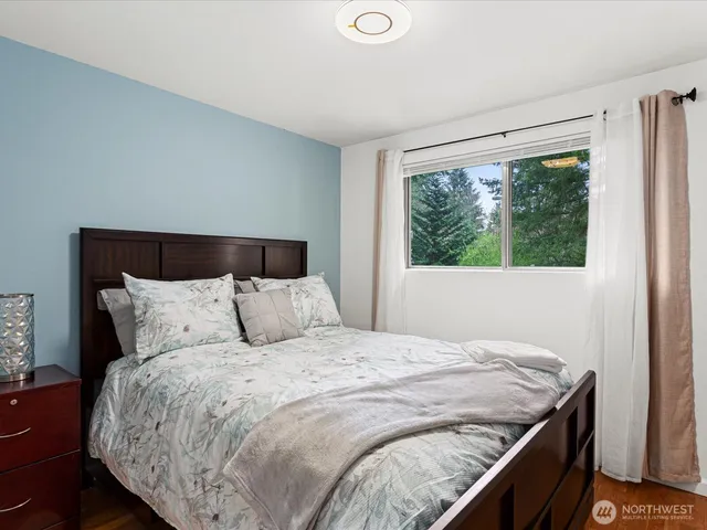 a large bed sitting in a bedroom next to a window