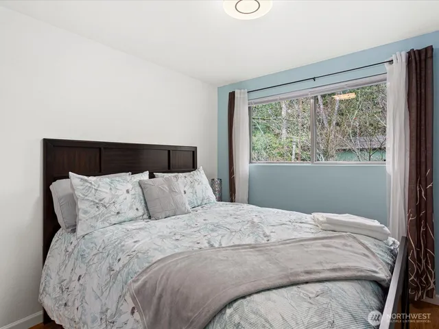 a large bed sitting in a bedroom next to a window