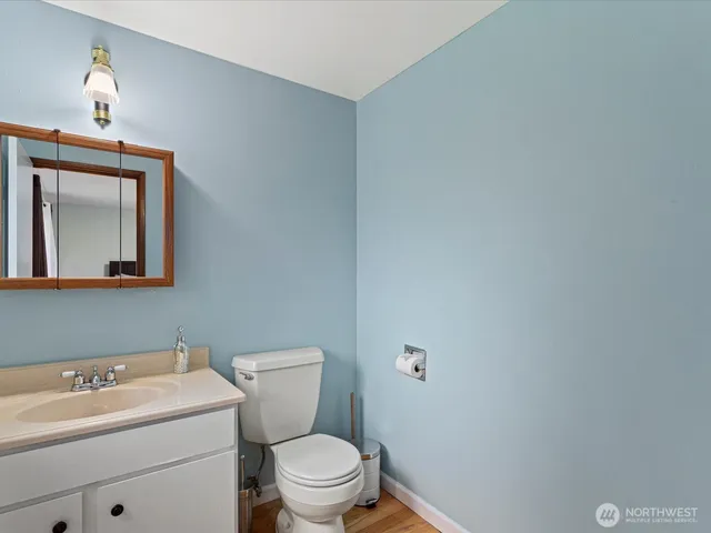 a bathroom with a toilet a sink and mirror