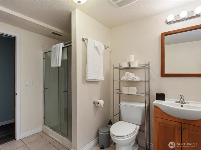 a bathroom with a sink a toilet and shower