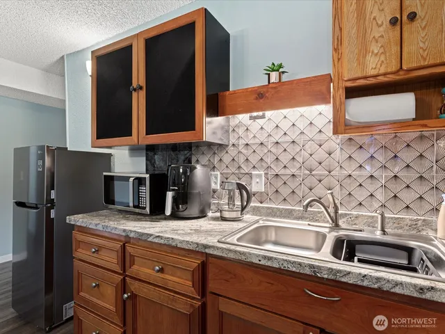 a kitchen with granite countertop a sink and a stove top oven