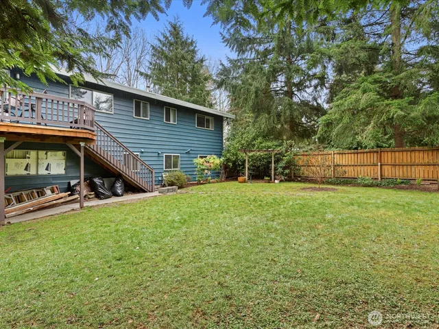 a view of backyard with swimming pool and deck