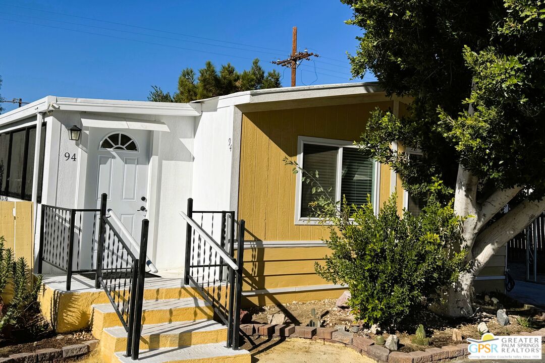 a view of a house with backyard and deck