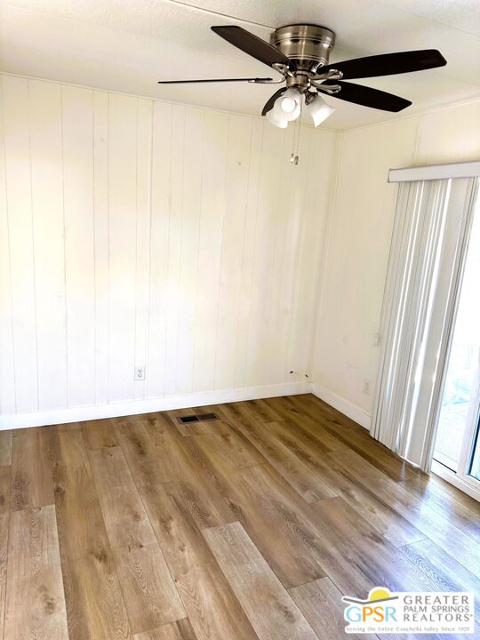 17850 Corkill Road, Unit 94 Desert Hot Springs, CA 92241 - Photo 14 of 39 a view of a room with wooden floor and a ceiling fan